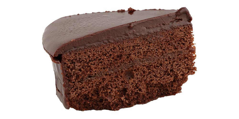 Sachertortenstück von der Seite vor weißem Hintergrund