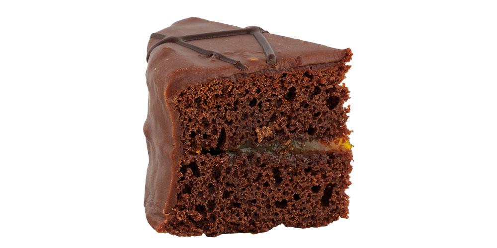 Sachertortenstück von der Seite vor weißem Hintergrund