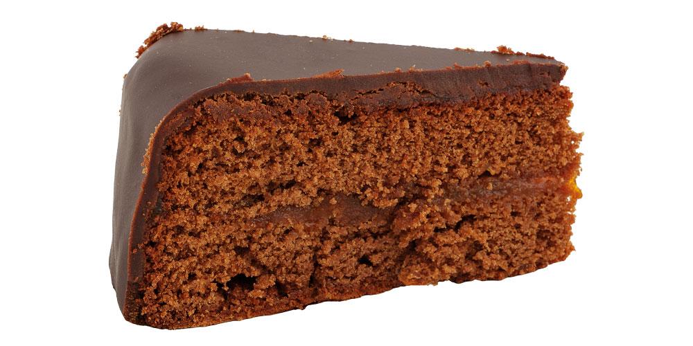 Sachertortenstück von der Seite vor weißem Hintergrund