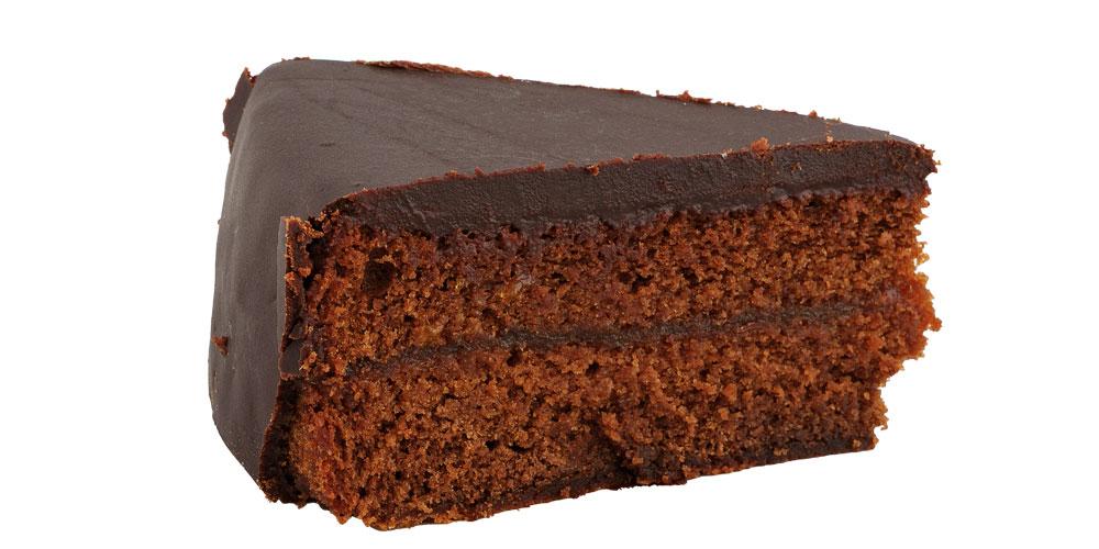 Sachertortenstück von der Seite vor weißem Hintergrund