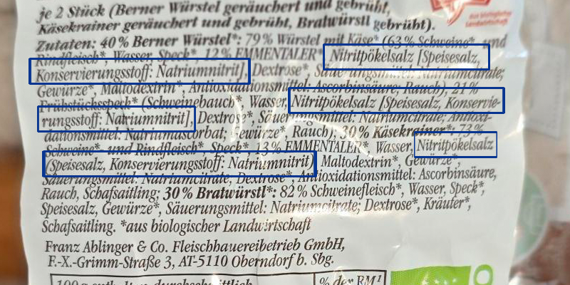 Zutatenliste einer Käsekrainer-Packung mit mehreren Sorten. Blau hervorgehoben ist die Angabe „Konservierungsstoff: E250&amp;quot;.