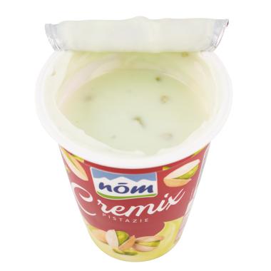 Ein geöffneter Becher Cremix Pistazien Joghurt von Nöm. 