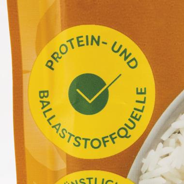 Die Aufrschrift "Protein- und Ballaststoffquelle" auf einer Packung eines reis-fit-Produkts.