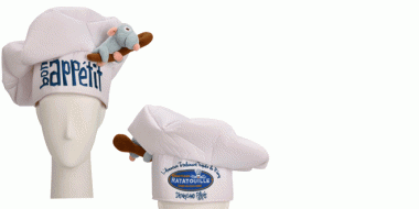 Weiße Kochmütze mit dem Schriftzug „Bon Appétit“ vorne und einem kleinen Plüsch-Remy (Ratte aus Ratatouille) an der Seite. Auf der Rückseite befindet sich ein Logo von Ratatouille: L’Aventure Totalement Toquée de Rémy aus dem Disneyland Paris.