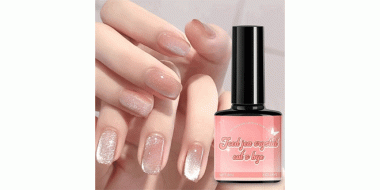 Das Bild zeigt eine Nahaufnahme von lackierten Fingernägeln sowie eine Flasche Nagellack. Die Fingernägel sind mit einem schimmernden, halbtransparenten Roséton lackiert, der einen „Cat’s Eye“-Effekt aufweist – ein leichter, schimmernder Lichtreflex, der dem Aussehen einer Katzenpupille ähnelt.