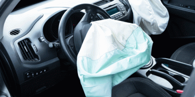 Zwei geöffnete, schlaffe weiße Auto-Airbags im vorderen Auto-Innenraum
