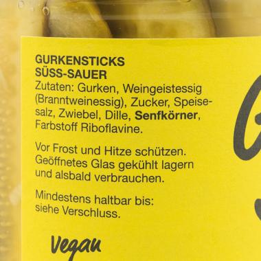 Die Zutatenliste der Südobst Gurken Sticks mit schwarzer Schrift auf gelbem Hintergrund. 