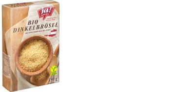 Die Kartonverpackung der „ja! Natürlich“ Bio-Dinkelbrösel zeigt eine rustikale Holzoptik mit einer Schale voller goldbrauner Brösel im Vordergrund. Das Produkt ist vegan, stammt aus österreichischem Bio-Dinkel und wiegt 350 g. Die Gestaltung betont Natürlichkeit.