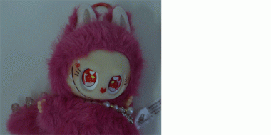 Ein Plüschanhänger in Form einer Puppe mit großem Kopf und pinkem, flauschigem Kostüm. Die Figur hat große, runde Augen mit Herzmustern, rote Wangen und kleine Hasenohren auf dem Kopf. Sie trägt eine Perlenkette um den Hals. Für Kenner:innen: ein Labubumonster.