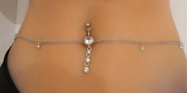 Frauenbauch mit Bauchnabelpiercing und -kette