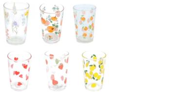 Die Abbildung zeigt sechs transparente Trinkgläser in zwei Reihen. Jedes Glas ist mit unterschiedlichen bunten Motiven bedruckt: zarte Blumen, orangefarbene Früchte, dicht gesetzte Orangenpunkte, rote Herzen, rote Früchte sowie gelbe Zitronen mit grünen Blättern. 