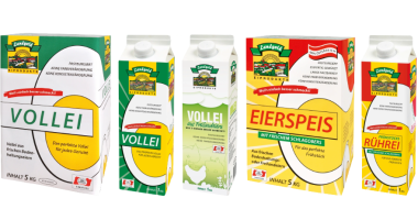 5 Verpackungen einer Molkereimarke in unterschiedlichen Größen und Ausführungen. Zu sehen sind Produkte mit den Bezeichnungen „Vollmilch“, „Vollmilch aus Freilandhaltung“, „Eierspeis“ und „Rührei“. Die Kartons sind überwiegend in Weiß gehalten und mit grünen, gelben sowie roten Designelementen gestaltet. Auf der Vorderseite befinden sich Produktnamen, Markenlogo, Illustrationen und Angaben zum Inhalt. Die Verpackungen sind nebeneinander vor weißem Hintergrund angeordnet.