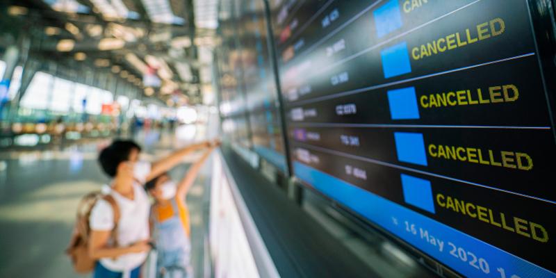 Mutter und Kind vor einer Anzeigetafel am Flughafen