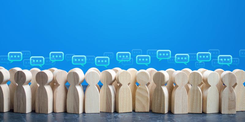 Holzmännchen mit Denkblase repräsentieren das Thema Umfrage