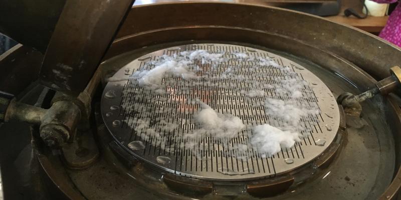 Brecht-Holl-Gerät. Nasse Papierreste auf ebenem Schlitzsieb