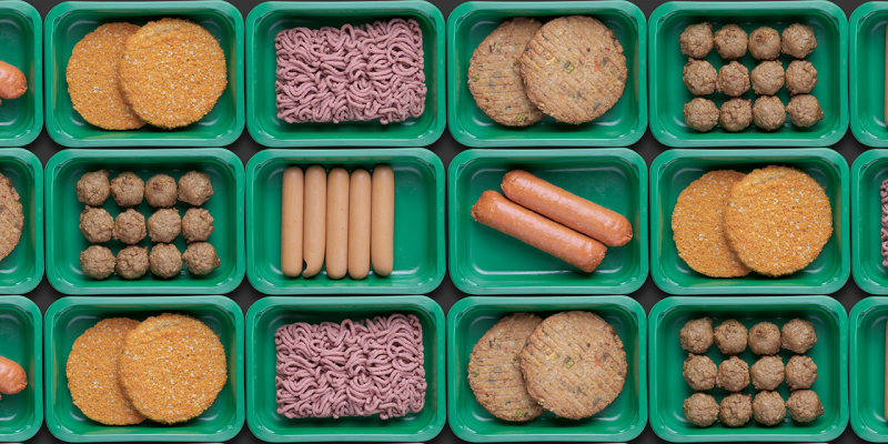 Verschiedene Fleischersatz-Produkte in grünen Verpackungen.