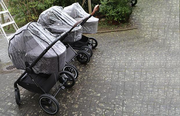 Drei Buggys nebeneinander mit ausgeklapptem Sonnenverdeck. Jeweils über Liegewanne und Sonnendeck ist ein Regenschutz gespannt.