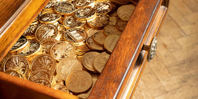 Gold kaufen - Edelmetall als Anlage: Tischlade voller Goldmünzen