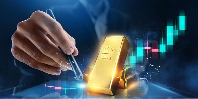 Gold kaufen - Edelmetall als Anlage: Fotografik mit Goldbarren und Hand mit Stift