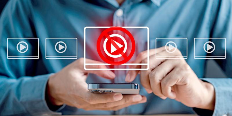 Mann tippt am Handy, darüber transparente Video Fenster und ein rotes Blockieren Symbol
