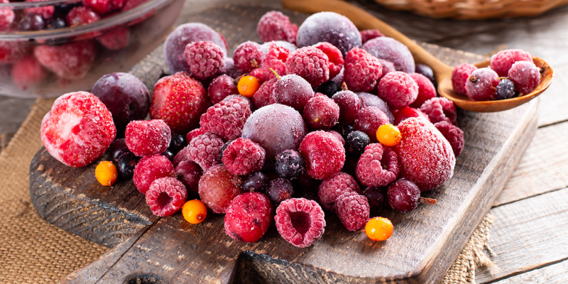 Gefrorene Beeren Test - Tiefkühlbeeren auftauen Beeren tiefgekühlt auf einem Holzbrett