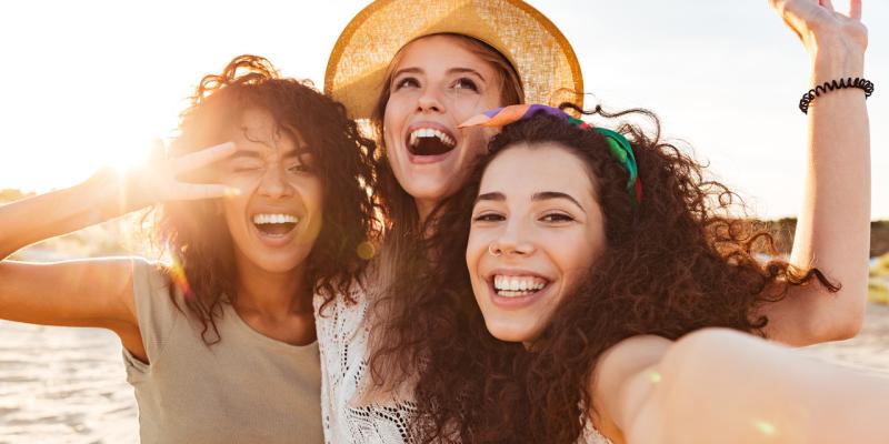 Drei Frauen in Sommerkleidung fröhlich Sonne Selfie