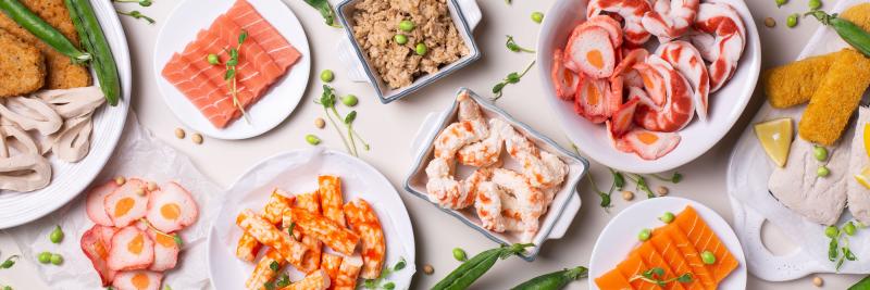 Viele weiße Teller mit veganen Fischprodukten darauf