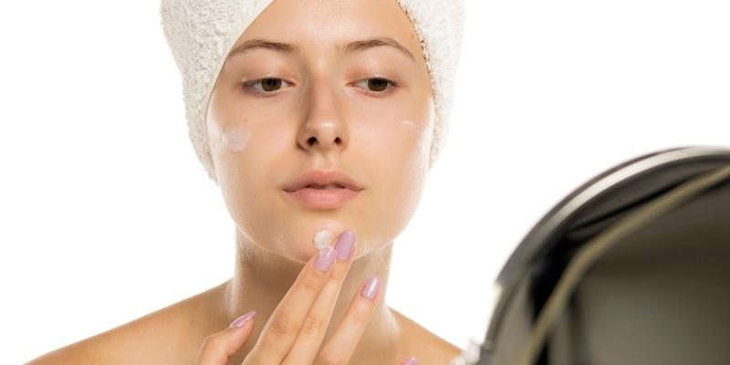 Frau cremt ihr Gesicht ein