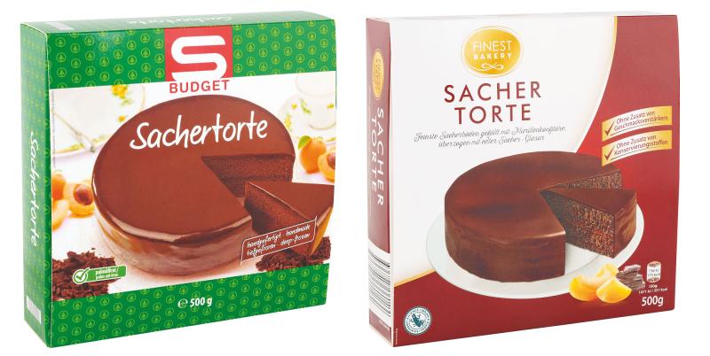 Das Bild zeigt zwei verpackte Sachertorten im Vergleich. Links ist eine grün‑weiße Verpackung der Marke „S Budget“ mit Abbildung einer runden, schokoladenglasierenden Torte und einem angeschnittenen Stück. Rechts ist eine rot‑weiße Verpackung der Marke „Finest Bakery“ zu sehen, ebenfalls mit einer ganzen Torte, einem Tortenstück sowie Fruchtsymbolen. Beide Packungen geben ein Gewicht von 500 Gramm an.