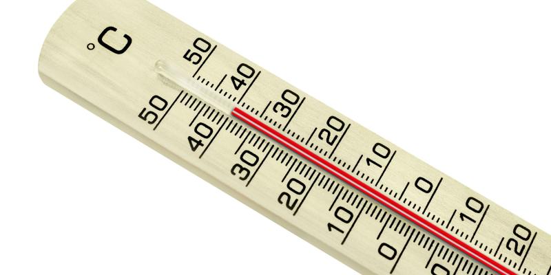 Das Bild zeigt eine Nahaufnahme eines Thermometers aus hellem Material vor einem neutralen, weißen Hintergrund. Die Skala ist sowohl in Grad Celsius als auch in Zahlen markiert und reicht bis über 50 Grad. Die rote Flüssigkeit im Inneren des Thermometers steht bei der 40‑Grad‑Marke. Die Zahlen und Markierungen sind gut erkennbar. Die hohe Anzeige deutet auf extreme Hitze hin.