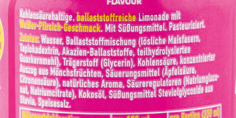 Verkehrsbezeichnung und Zutatenliste. „Kohlensäurehaltige, ballaststoffreiche Limonade mit Weißer-Pfirsich-Geschmack. Mit Süßungsmittel. Pasteurisiert.“ Zutaten unter anderem Wasser, eine Ballaststoffmischung, Glycerin, Auszug aus Mönchsfrüchten, natürliches Aroma, Kokosöl und Steviolglycoside aus Stevia.