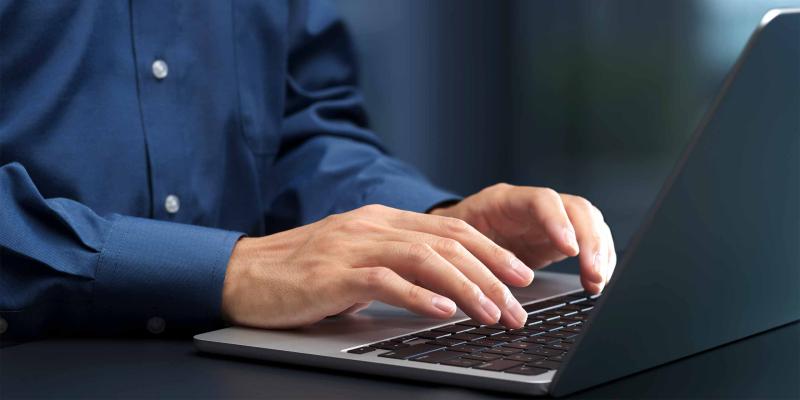 Männerhände an der Notebook-Tastatur