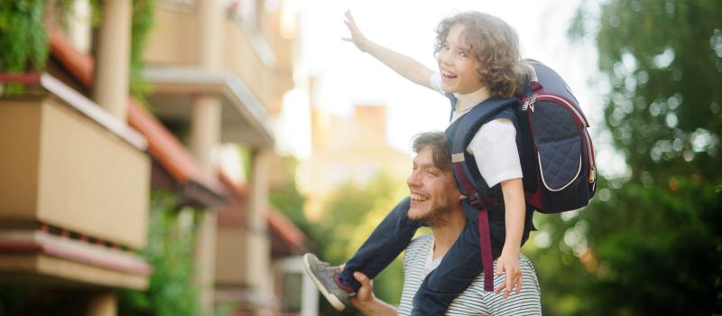Papa mit Volksschulkind auf den Schultern