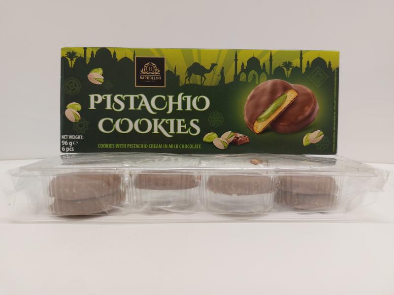 Grüne Packung „Bardollini Pistachio Cookies“ mit Abbildung von mit Milchschokolade überzogenen Keksen mit Pistaziencreme. Darunter liegt die transparente Kunststoffschale mit den Keksen.
