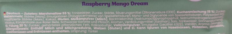 Nahaufnahme der Zutatenliste auf der grünen Verpackung „Raspberry Mango Dream“. Aufgeführt sind unter anderem Marshmallow, Kuchenmischung und Füllung; der Allergenhinweis nennt Milch, Weizen (Gluten) und Ei sowie mögliche Spuren von Nüssen und Erdnüssen.